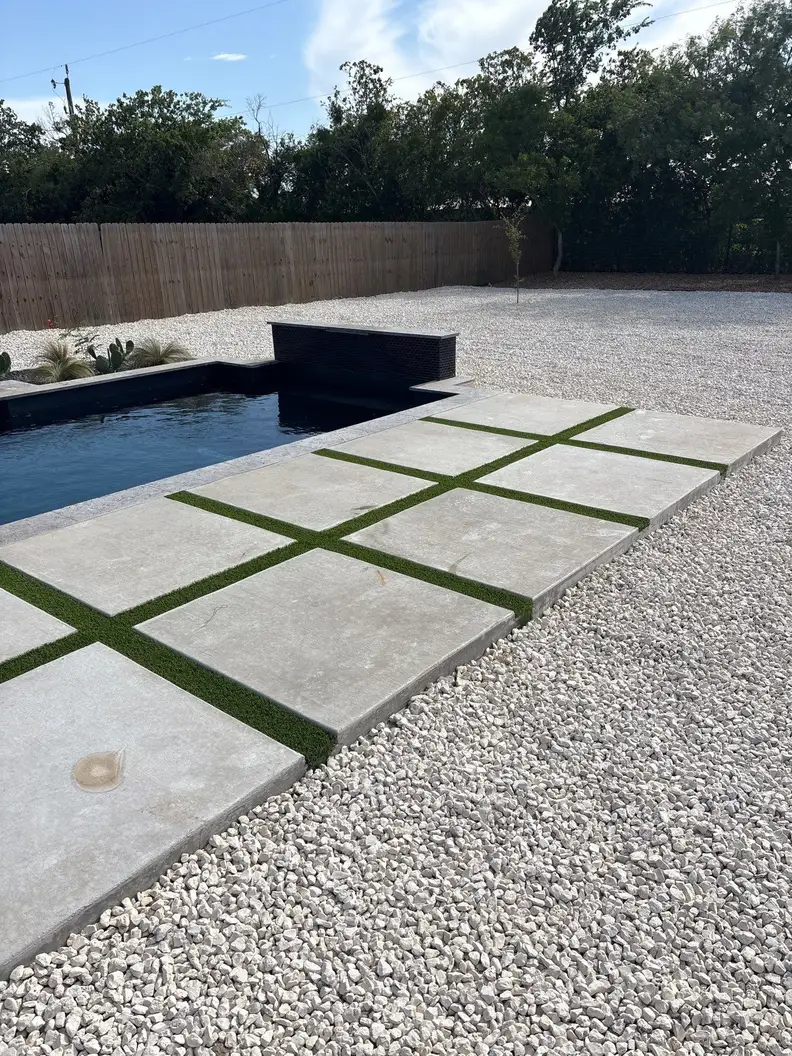 Pool and spa with oversized concrete pavers set in pale gravel