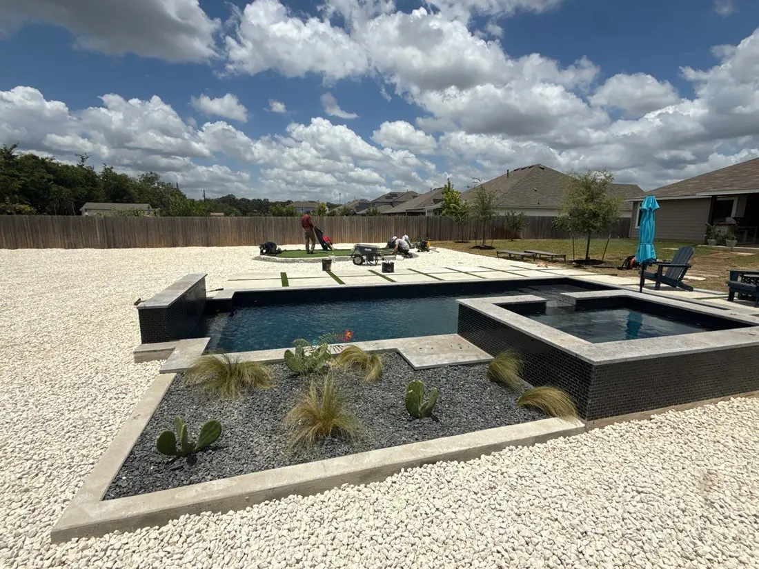 Zero-mow gravel backyard with raised planter beds around the pool