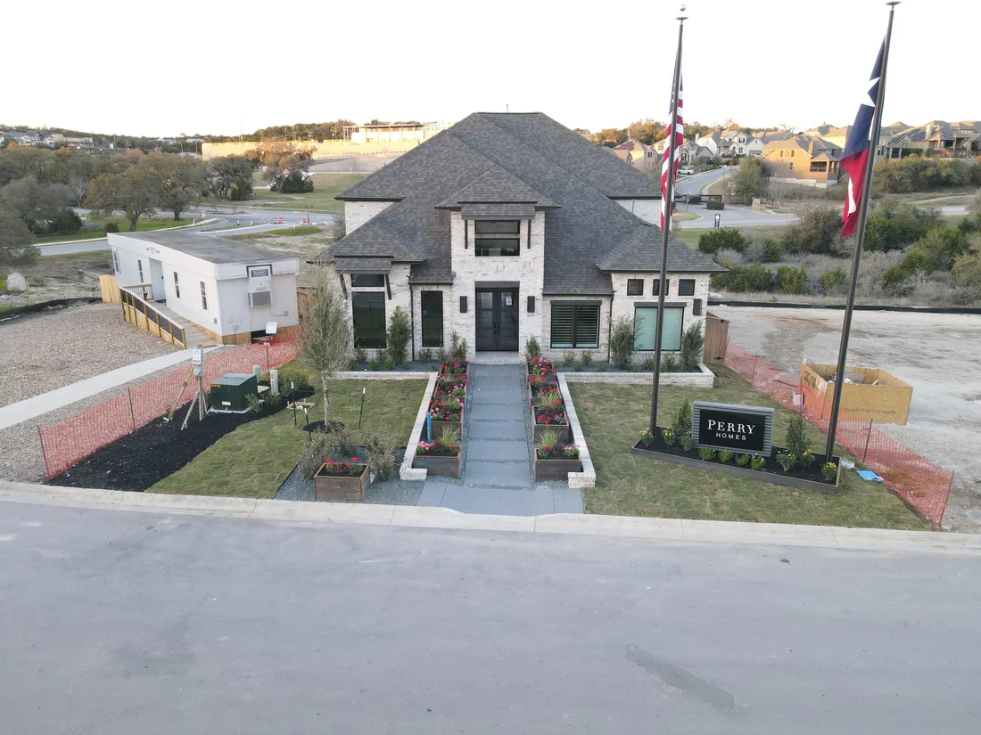 Front elevation of the Johnson Ranch model home with flagpoles and the entry walkway