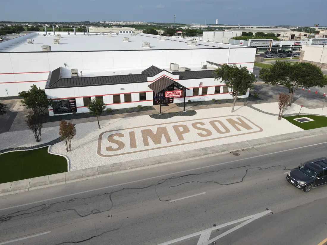 Aerial view of the Simpson Racing frontage with the company name laid out in the gravel forecourt