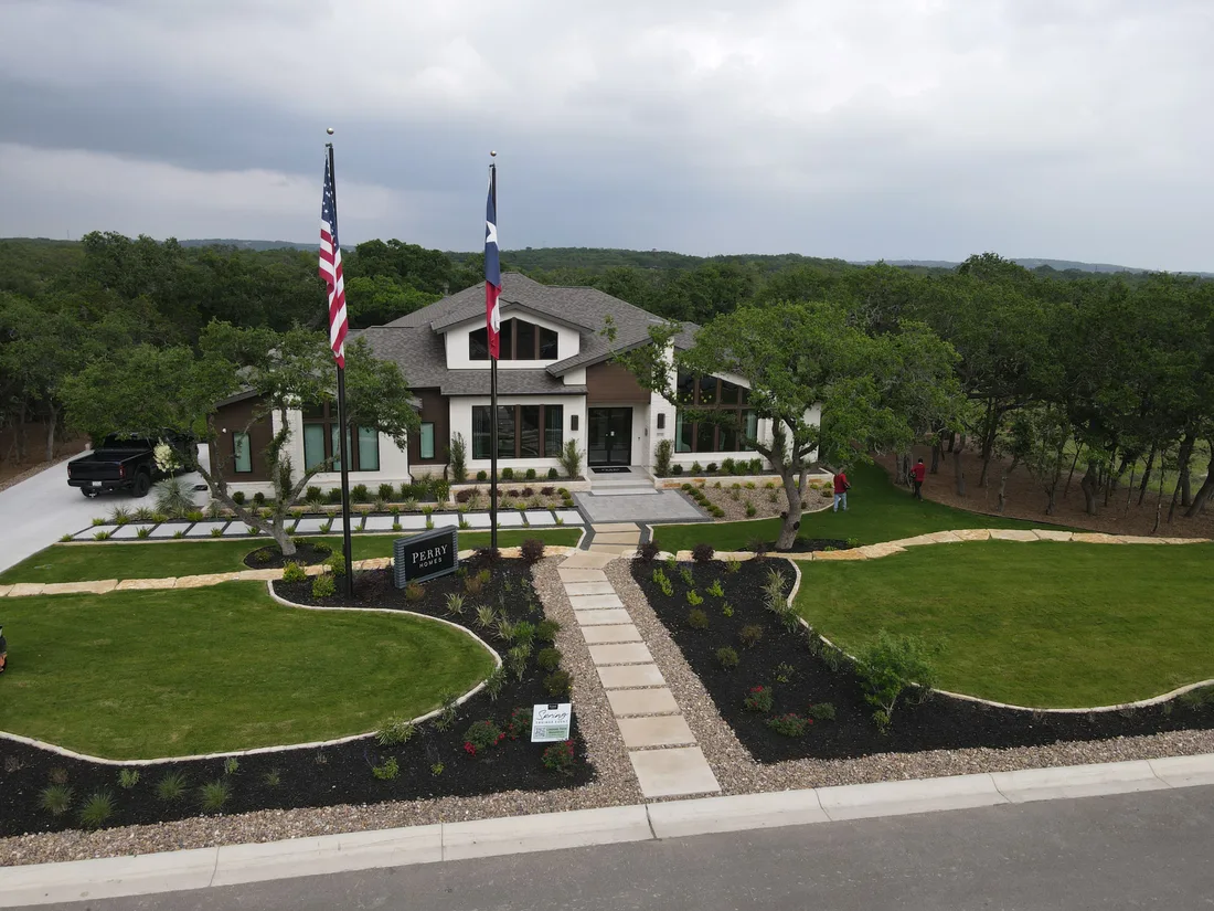 Perry Homes model home at Thornebrooke with a curving front lawn and flagpoles