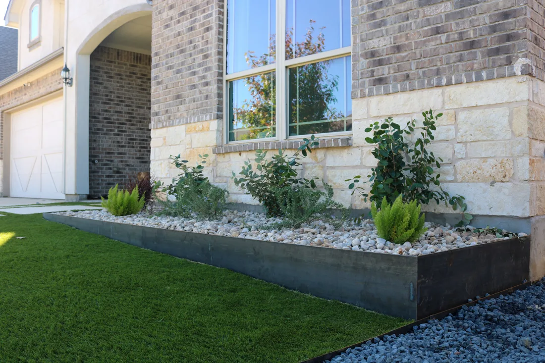 A steel edged foundation bed filled with river rock, carrying runoff clear of the wall