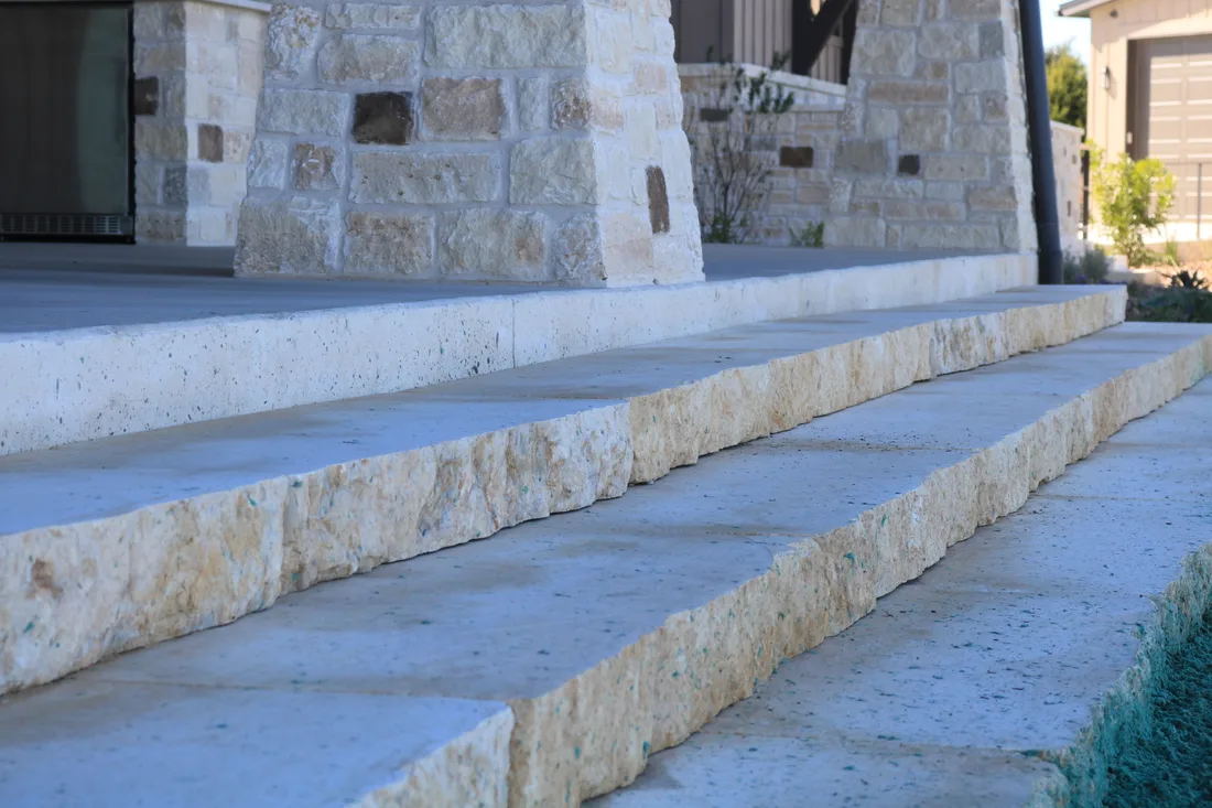 Solid cut limestone slab steps running up to a stone column