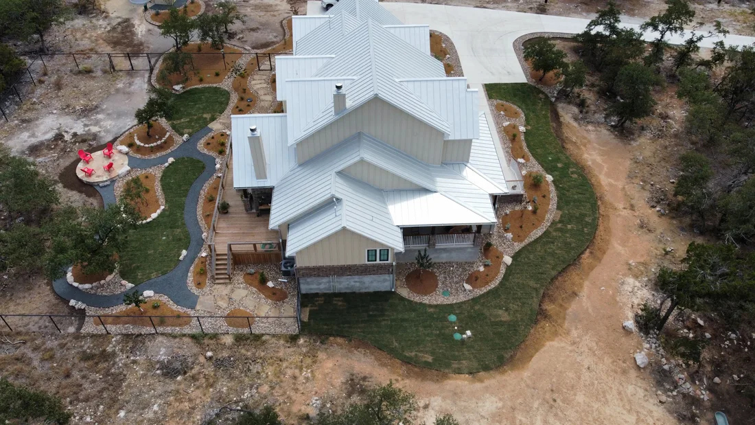 Overhead view of a landscape design wrapping a Hill Country home, with curved gravel beds and paths cut through native ground