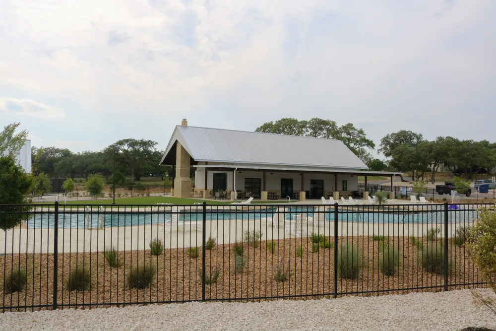The Belle Oaks pool and pavilion seen across a planted fence line