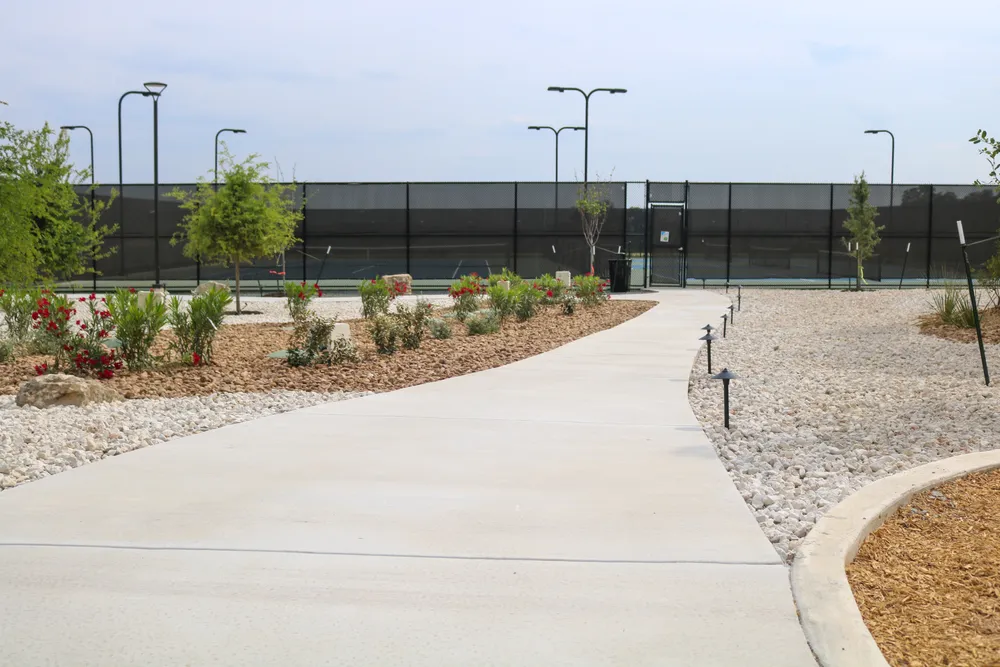 Concrete walkway curving through planted beds at the Belle Oaks grounds