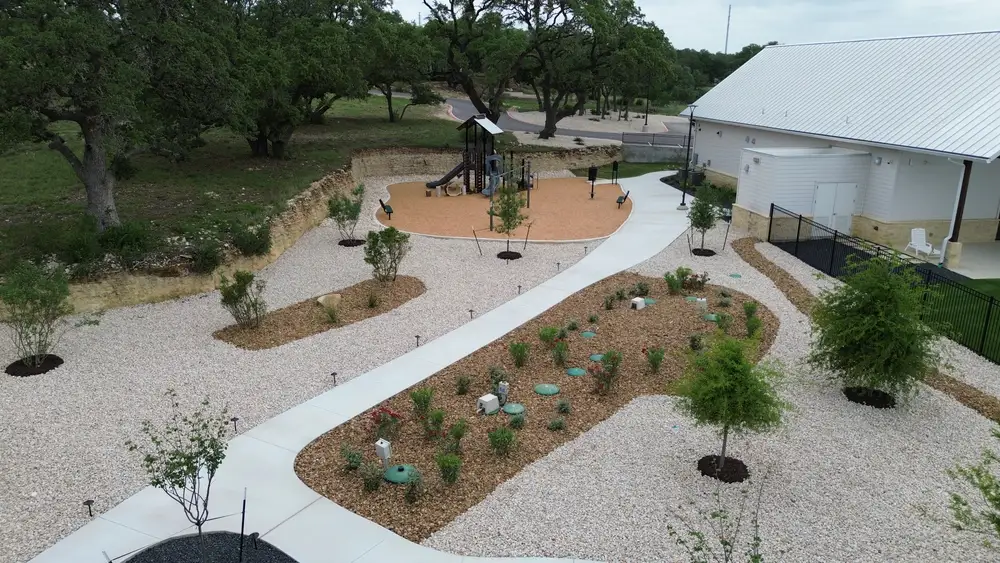 Aerial view of the Belle Oaks grounds with curving paths, planted beds, and the playground