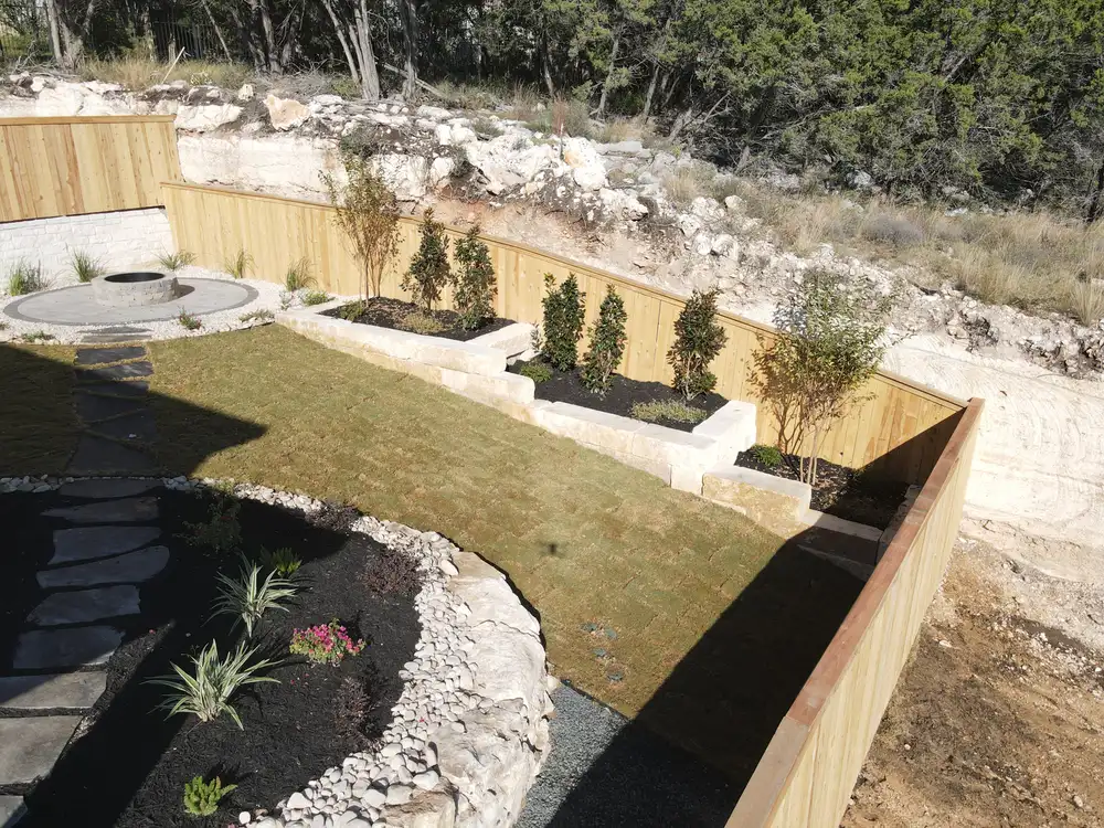 Aerial view of planted limestone terraces stepping down a steep lot
