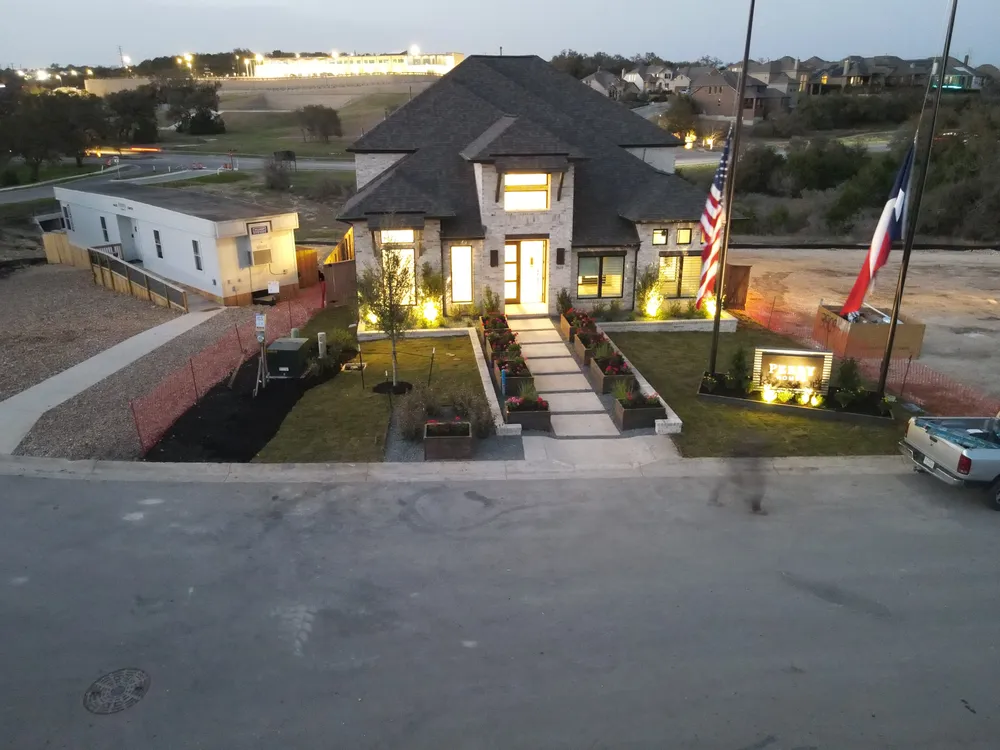 The Perry Homes model home at Johnson Ranch at dusk with the landscape lighting on
