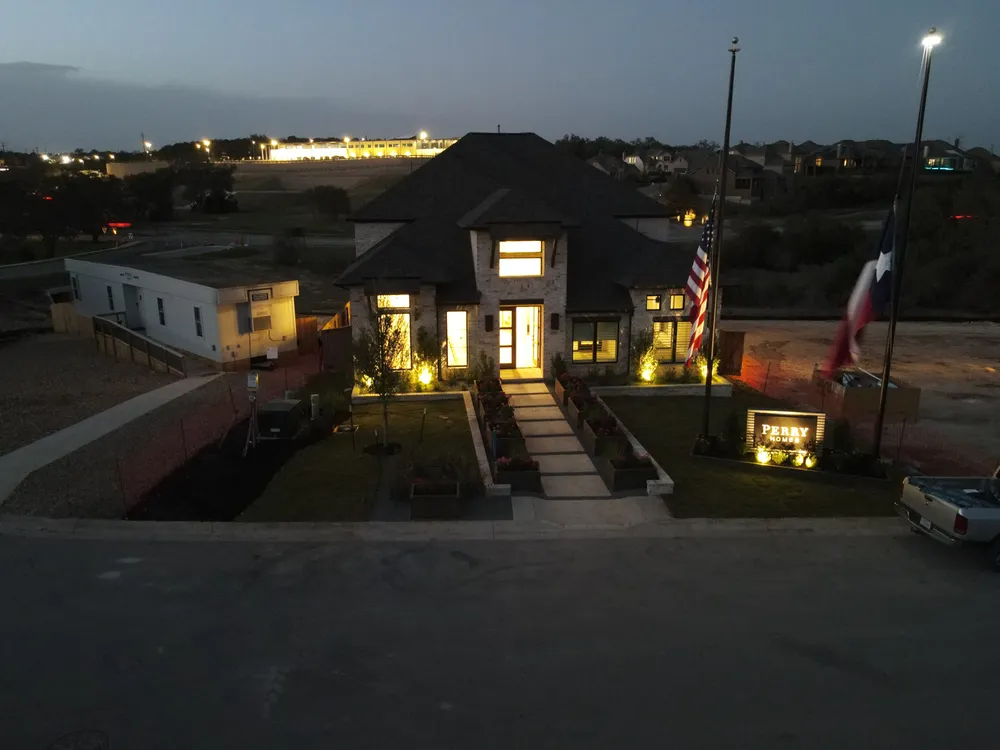 Aerial view of the Johnson Ranch model home at dusk with the entry lit
