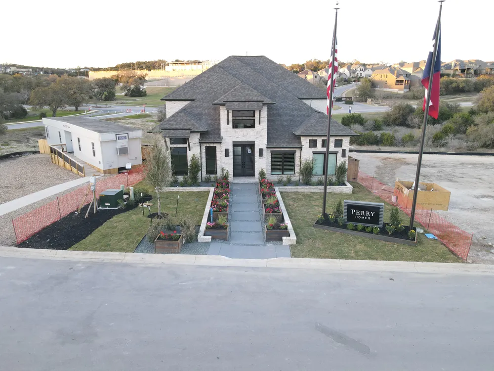 The Johnson Ranch model home by day, with flagpoles and the paver entry walk