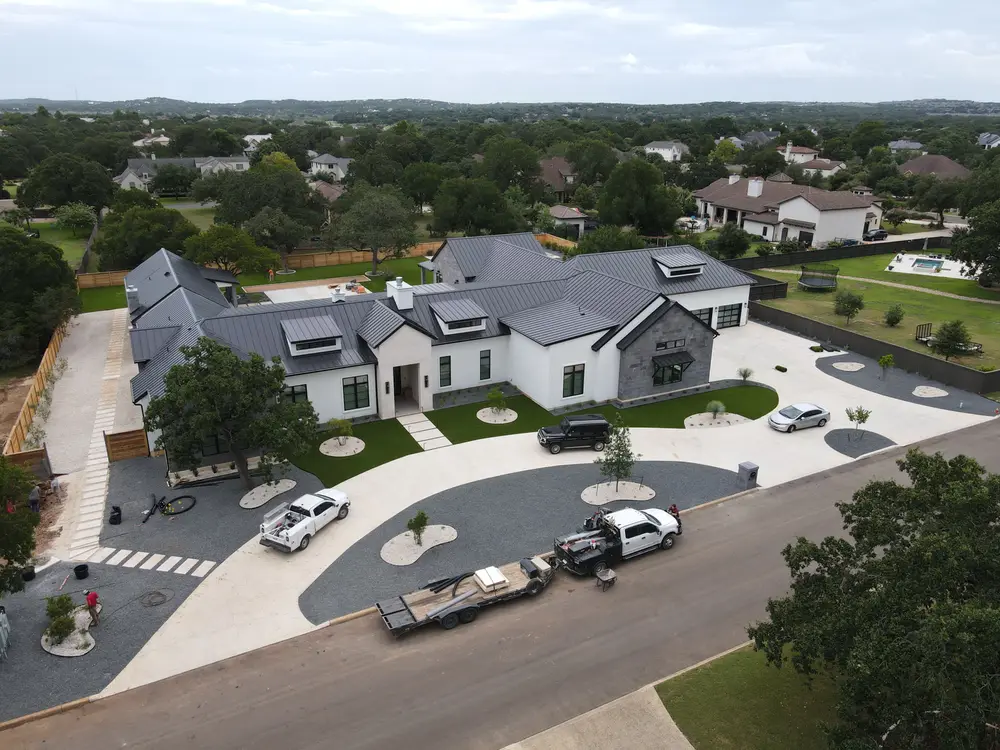 Aerial view of a home with a circular drive and a new front lawn