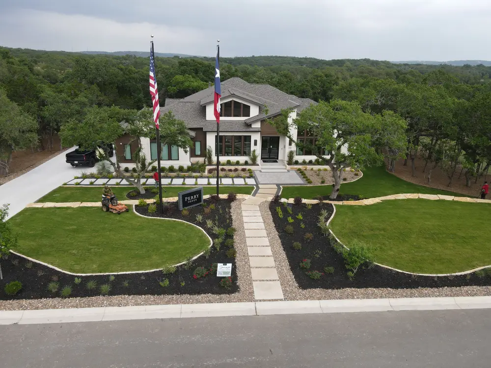 Perry Homes model home at Thornebrooke with flagpoles and a curving front lawn