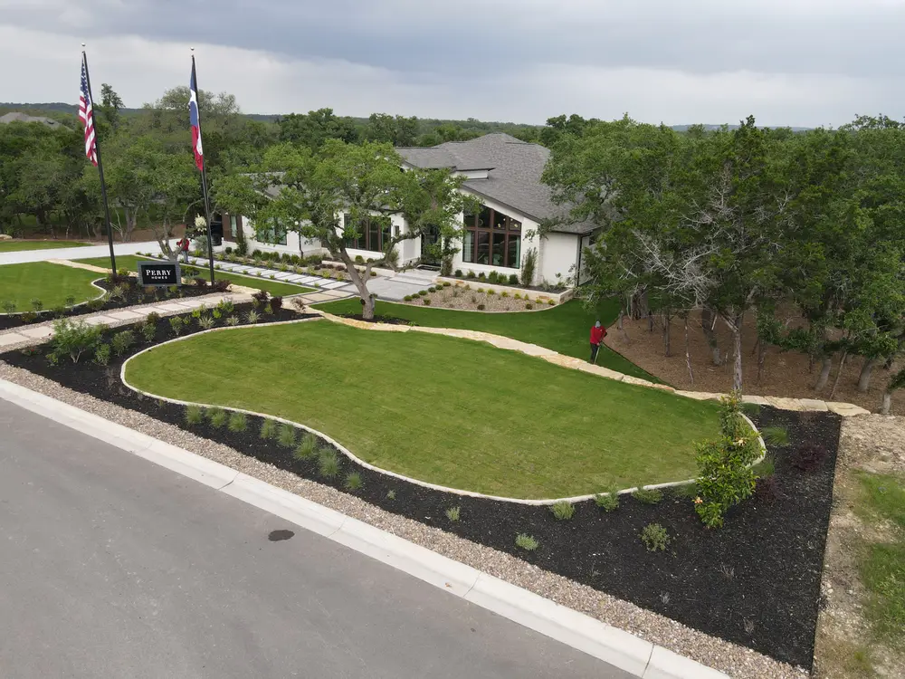 Curving front lawn edged in deep mulch beds under mature live oaks